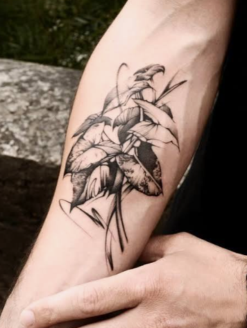 Black and grey fine line tattoo reference with detailed botanical flowers on a forearm