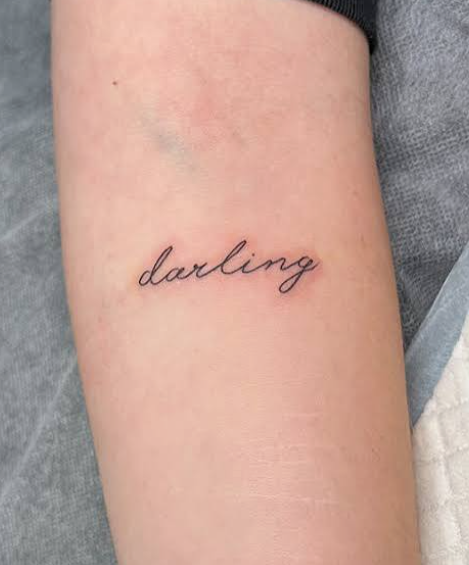 Fine line script tattoo reference showing the word darling on an arm